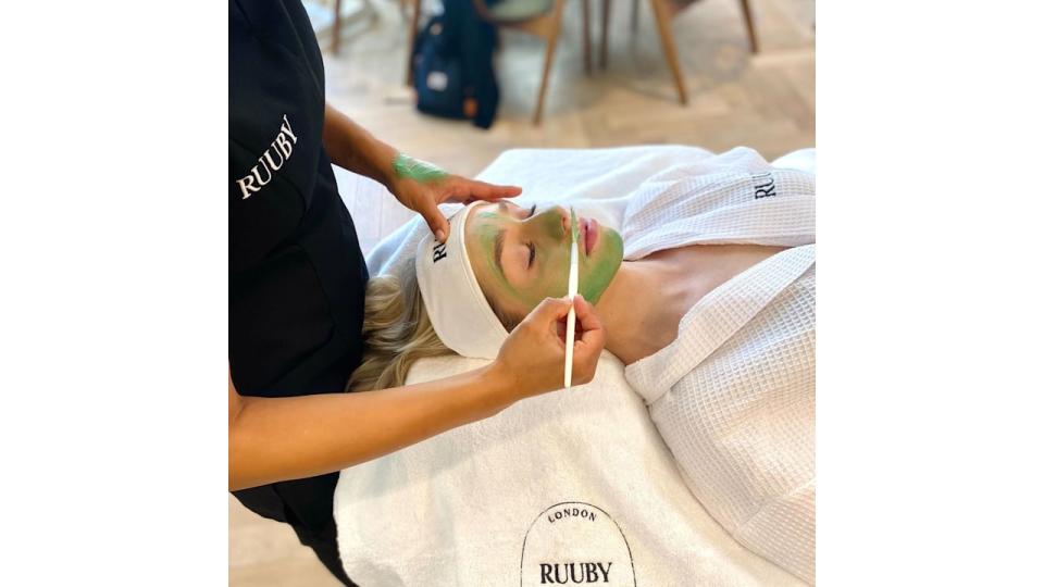 Woman having face mask applied on treatment bed