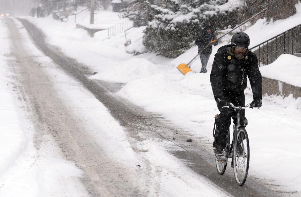 A man rides his bicycle during a snow storm in Toronto