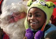 Faith Callion, 8, smiles as she sits with Santa Claus at the Los Angeles Mission's Christmas meal service and toy giveaway at skid row in Los Angeles, California December 24, 2013. REUTERS/Jonathan Alcorn (UNITED STATES - Tags: SOCIETY)