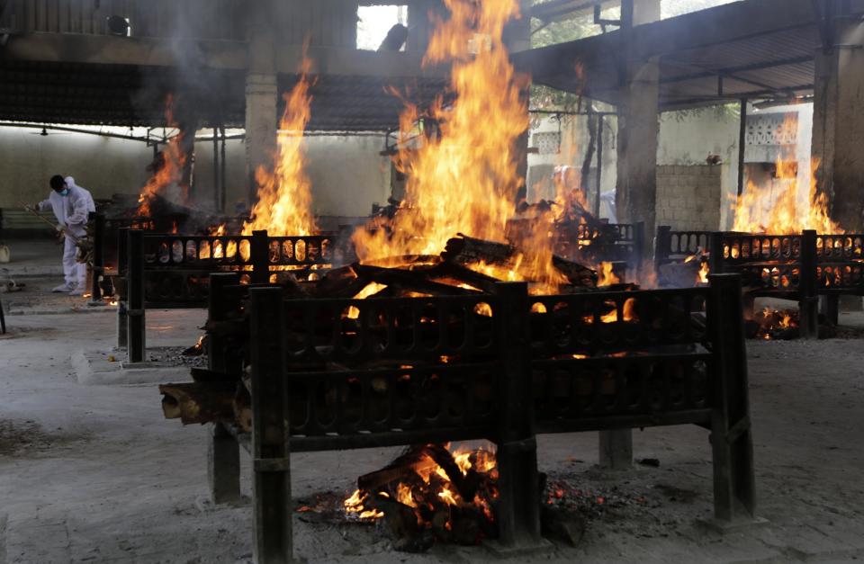 Flames rise from cremation pyres of victims of a fire that broke out in Vijay Vallabh COVID-19 hospital, at Virar, near Mumbai, India, Friday, April 23, 2021. A fire killed 13 COVID-19 patients in a hospital in western India early Friday as an extreme surge in coronavirus infections leaves the nation short of medical care and oxygen. (AP Photo/Rajanish Kakade)