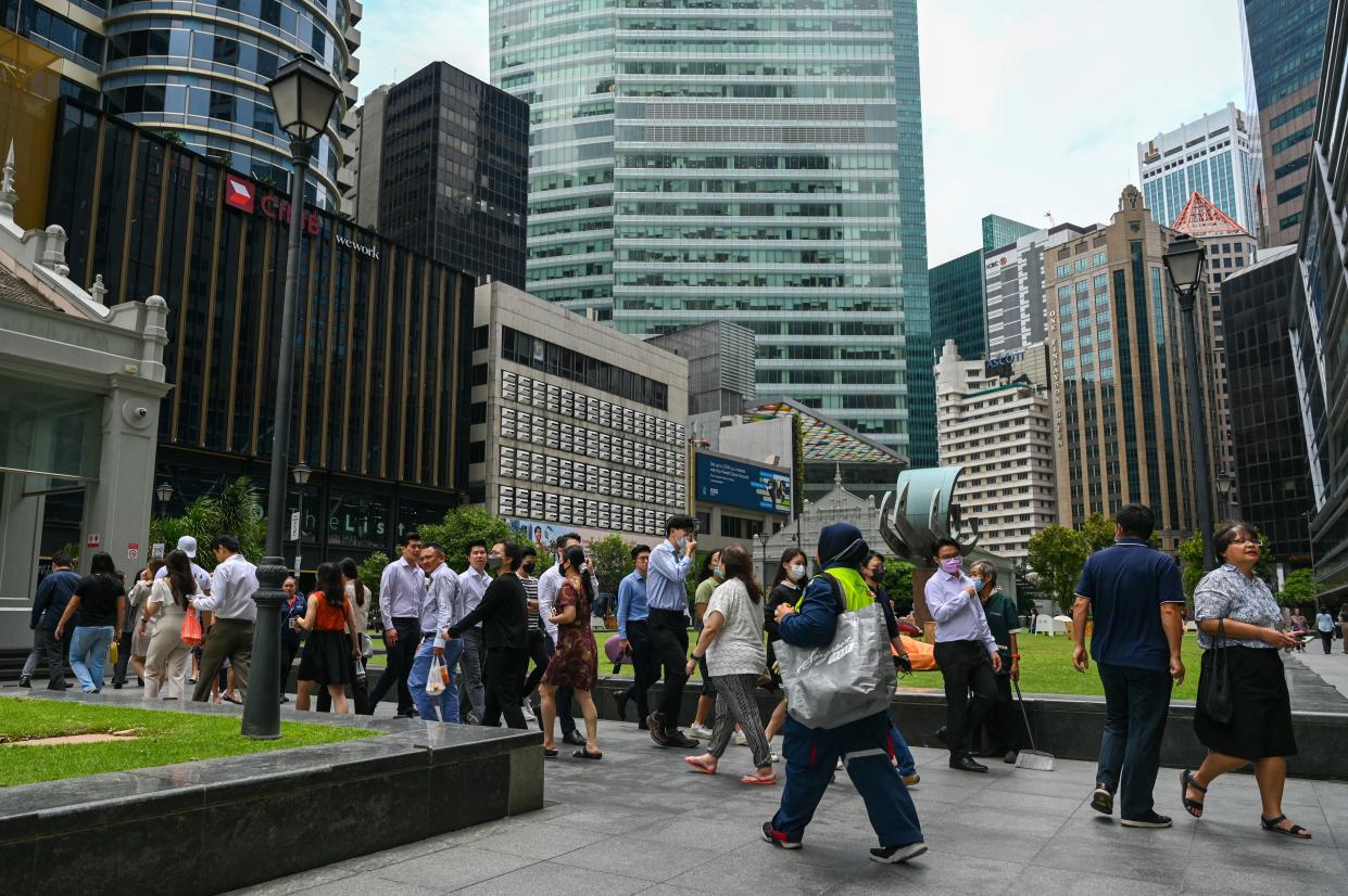 Office workers walk out for a lunch break at Raffles Place financial business district in Singapore on October 6, 2022. (Photo by Roslan RAHMAN / AFP) (Photo by ROSLAN RAHMAN/AFP via Getty Images)