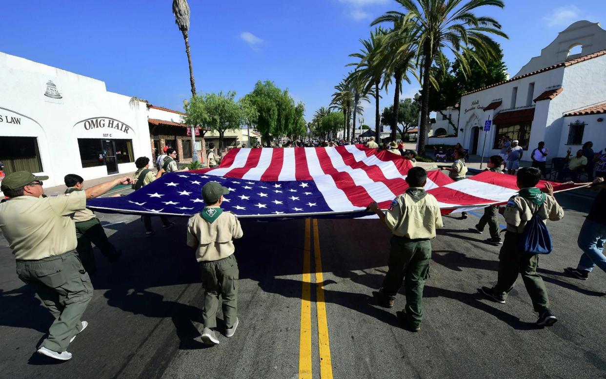 The US flag is carried by Boy Scouts during a parade  - AFP