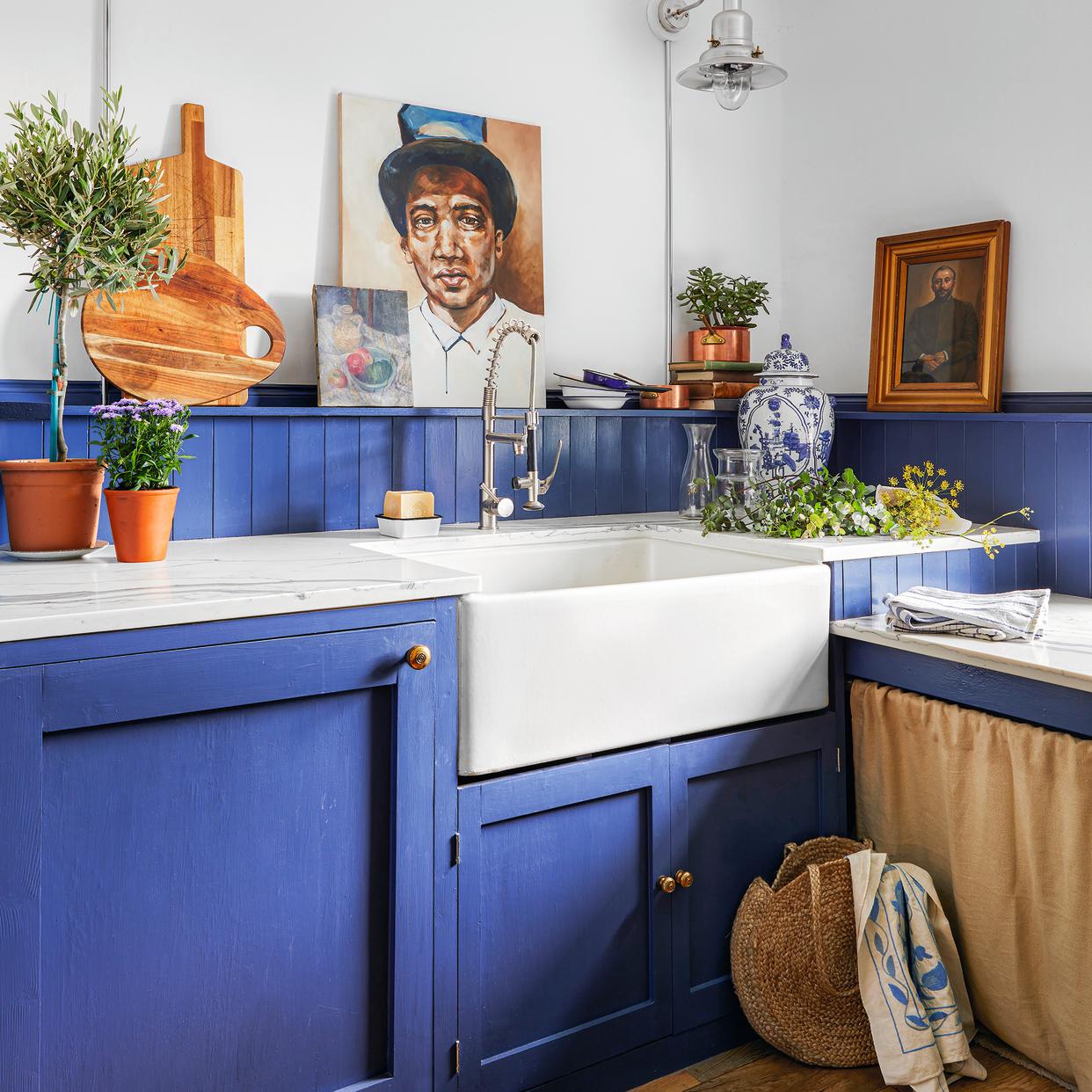  Mediterranean blue kitchen with shaker cupboards, belfast sink and herringbone flooring. 