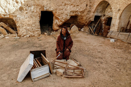 Mustapha, 54, a farmer, sits in the corridor of his his family's troglodyte house which was converted to a warehouse, on the outskirts of Matmata, Tunisia, February 4, 2018. REUTERS/Zohra Bensemra