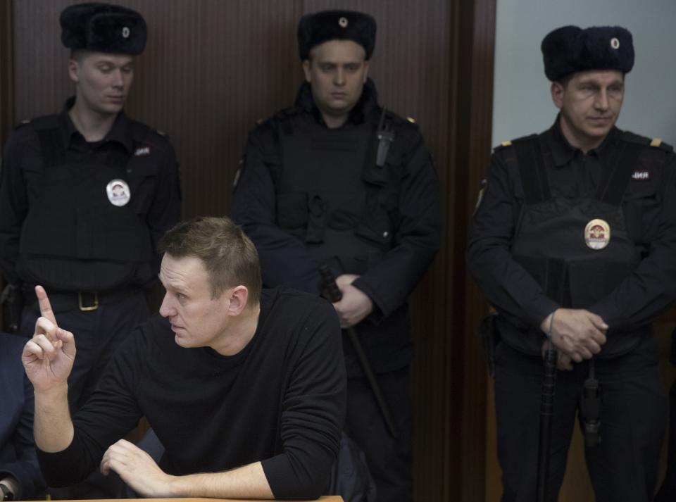 Russian opposition leader Alexei Navalny, foreground left, gestures speaking in court in Moscow, Russia, Thursday, March 30, 2017. Many Western countries have condemned the arrests and called for the release of those sentenced to jail, including opposition leader Alexei Navalny, Putin's most prominent foe. (AP Photo/Pavel Golovkin)