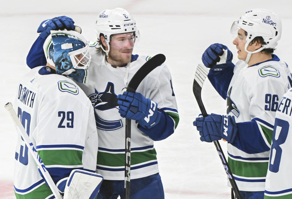 Vancouver Canucks goaltender Casey DeSmith (29) is congratulated by teammates Brock Boeser (6) and Andrei Kuzmenko (96) after defeating the Montreal Canadiens in an NHL hockey game in Montreal, Sunday, Nov. 12, 2023. (Graham Hughes/The Canadian Press via AP)
