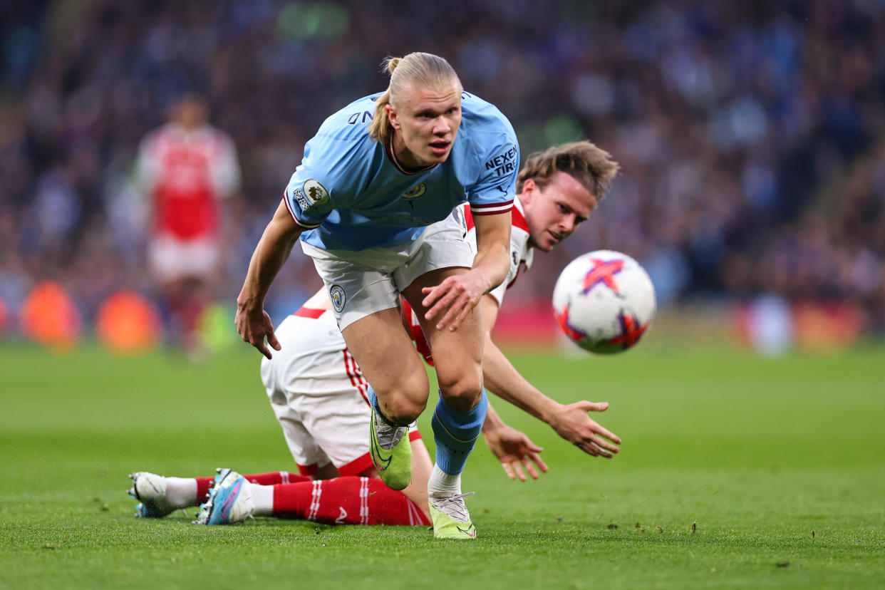 Manchester City's Erling Haaland bulldozes past Arsenal's Rob Holding during their English Premier League clash at Etihad Stadium.