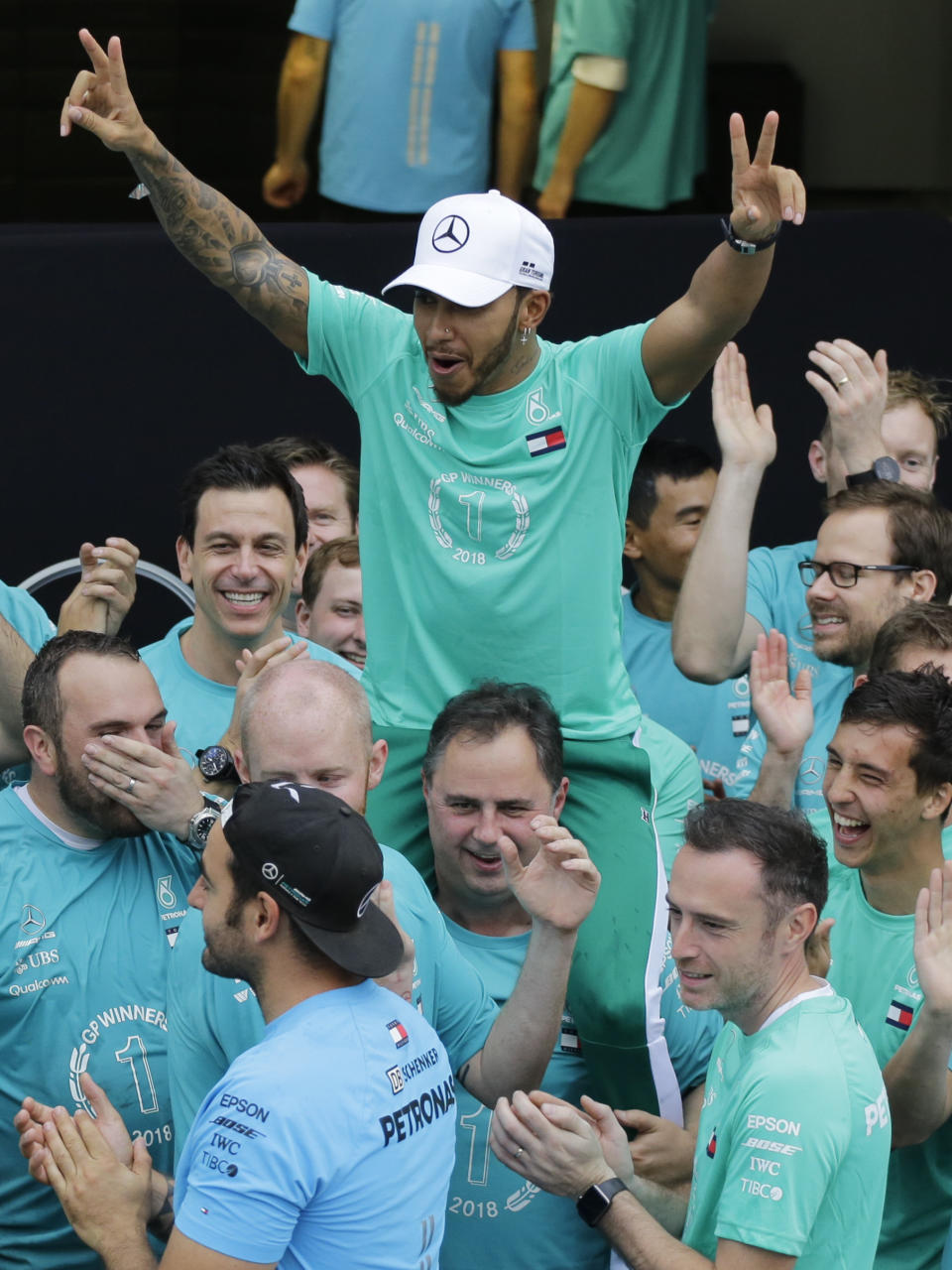 Lewis Hamilton, of Britain, celebrates with members of the Mercedes Benz team after the Brazilian Formula One Grand Prix at the Interlagos race track in Sao Paulo, Brazil, Sunday, Nov. 11, 2018. Five-time world champion Lewis Hamilton won the race helping his team to take the constructors' title. (AP Photo/Nelson Antoine)