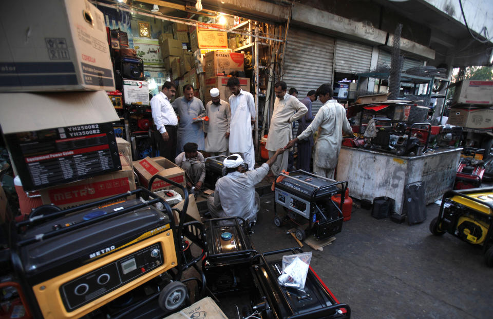 FILE - In this Tuesday, May 28, 2013 file photo, Pakistani customers buying and getting their generators, which are widely used due to long hours of power cuts, in Rawalpindi, Pakistan. Cash-strapped Pakistan should pursue clean energy instead of relying on coal, nuclear and hydroelectric power, according to a report released Wednesday urging the country's policymakers to rethink plans for building more coal-fired plants. (AP Photo/B.K. Bangash, File)