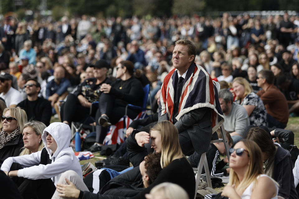 People in Hyde Park watch the State Funeral Service of Britain's Queen Elizabeth II on giant screens, Monday, Sept. 19, 2022 in London. The Queen, who died aged 96 on Sept. 8, will be buried at Windsor alongside her late husband, Prince Philip, who died last year. (AP Photo/Lewis Joly)