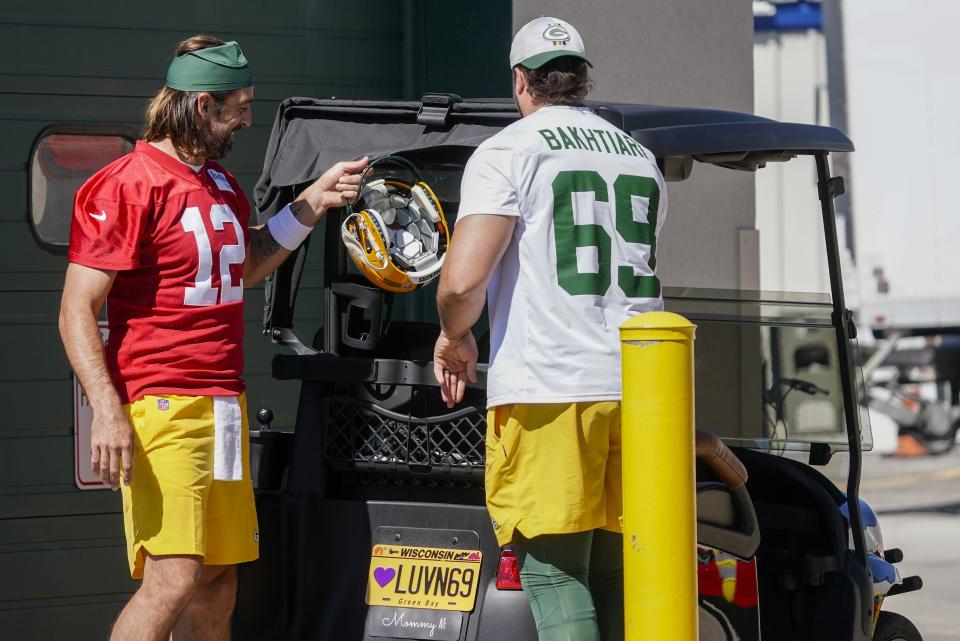 Green Bay Packers' Aaron Rodgers and David Bakhtiari arrive on a golf cart to the NFL football team's practice field Saturday, July 30, 2022, in Green Bay, Wis. (AP Photo/Morry Gash)