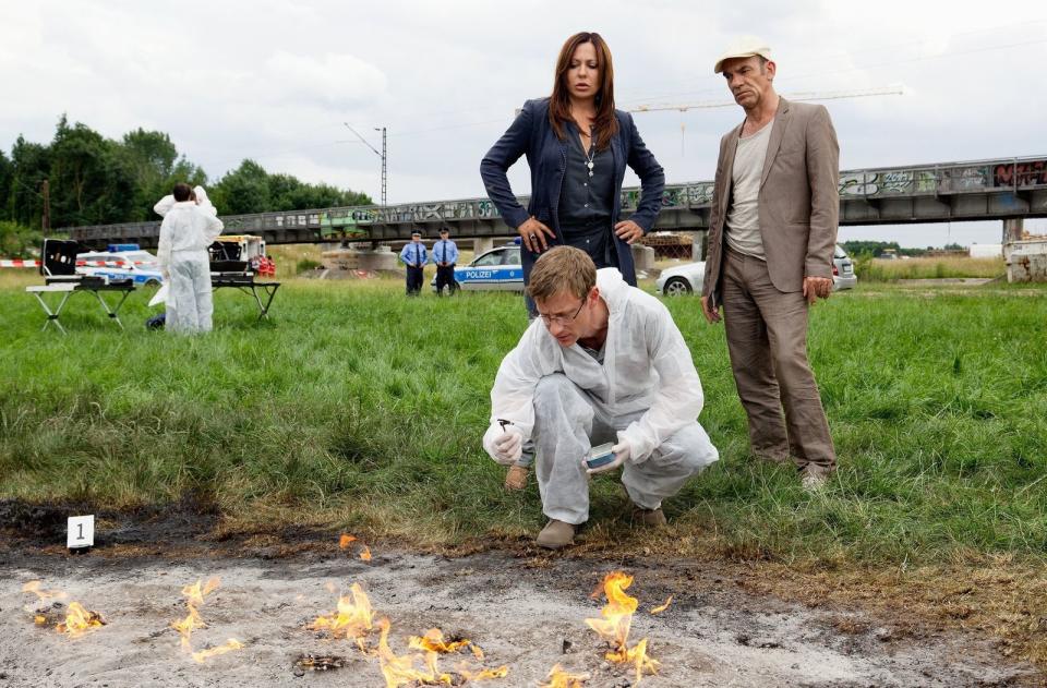 Wie Sie sehen, sehen Sie nichts! Auch das gab's beim "Tatort": einen Leichenfund ohne Leiche. Wie Kriminaltechniker Menzel (Maxim Mehmet, vorne) den Leipziger Hauptkommissaren Saalfeld (Simone Thomalla) und Keppler (Martin Wuttke) in der Folge "Schwarzer Afghane" (2013) erklärt, ist ein Mann mit Phosphor in Berührung gekommen und nahezu rückstandslos verbrannt. (Bild: MDR / Junghans)