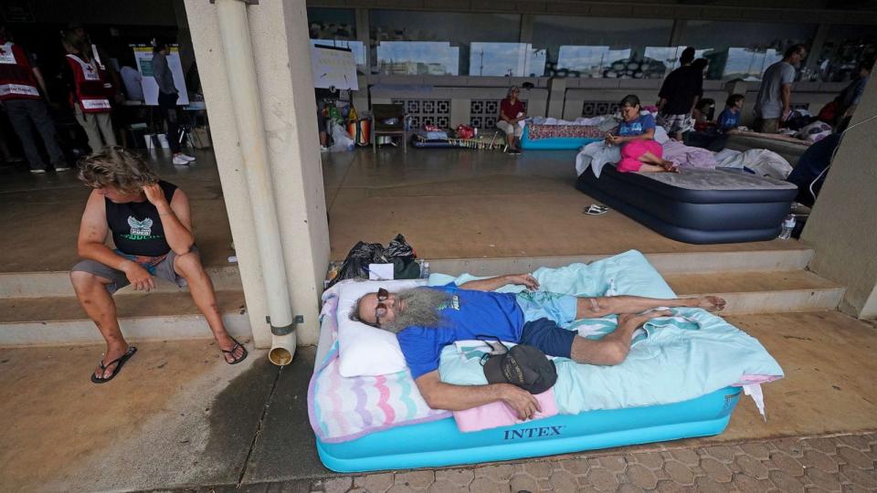 PHOTO: Thomas Leonard lies on an air mattress at an evacuation center at the War Memorial Gymnasium after his Lahaina apartment was destroyed by wildfire, Aug. 10, 2023, in Wailuku, Hawaii. (Rick Bowmer/AP)