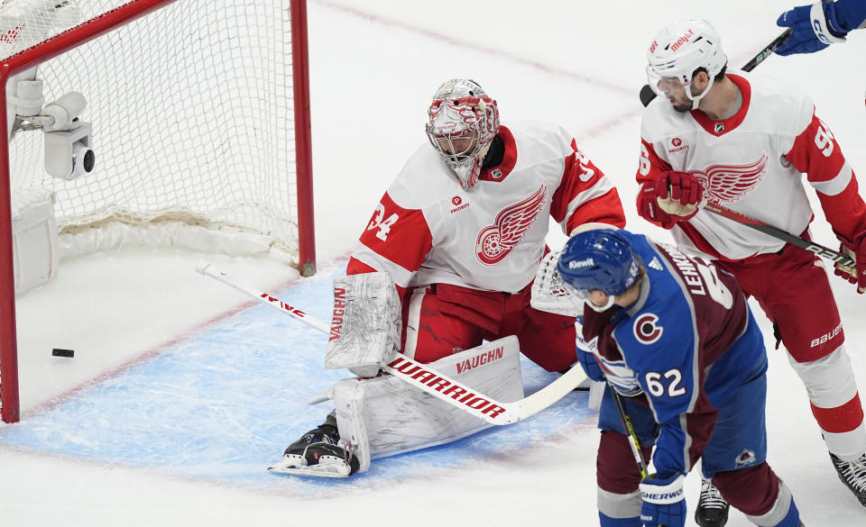Detroit Red Wings goaltender Alex Lyon, left, allows a goal by Colorado Avalanche defenseman Cale Makar as left wing Artturi Lehkonen, front right, and Detroit defenseman Jake Walman look on in the first period of an NHL hockey game Wednesday, March 6, 2024, in Denver. (AP Photo/David Zalubowski)