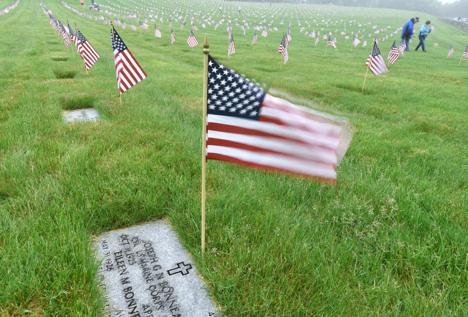 A breeze sets the flags alive along the rows of headstones at the National Cemetery in Bourne where hundreds of volunteers gathered to place tens of thousands of flags on all the veterans' grave in honor of Memorial Day. 
Steve Heaslip/Cape Cod Times