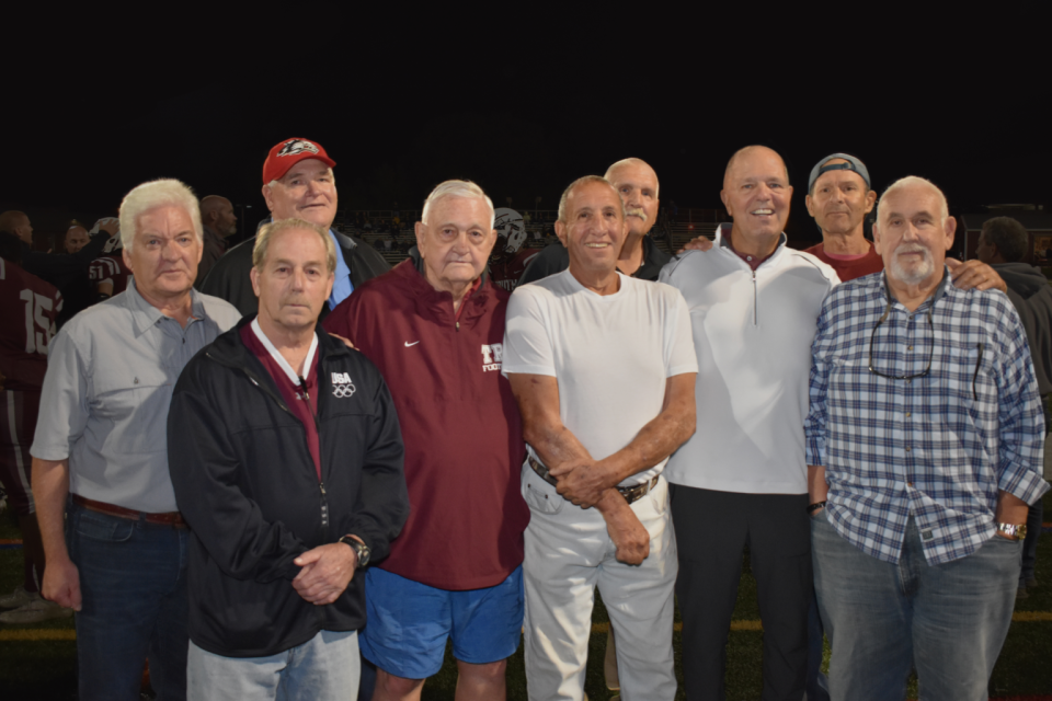 Former Toms River South players surround former head coach Ron Signorino (fourth from left) at a game in Toms River in 2021.