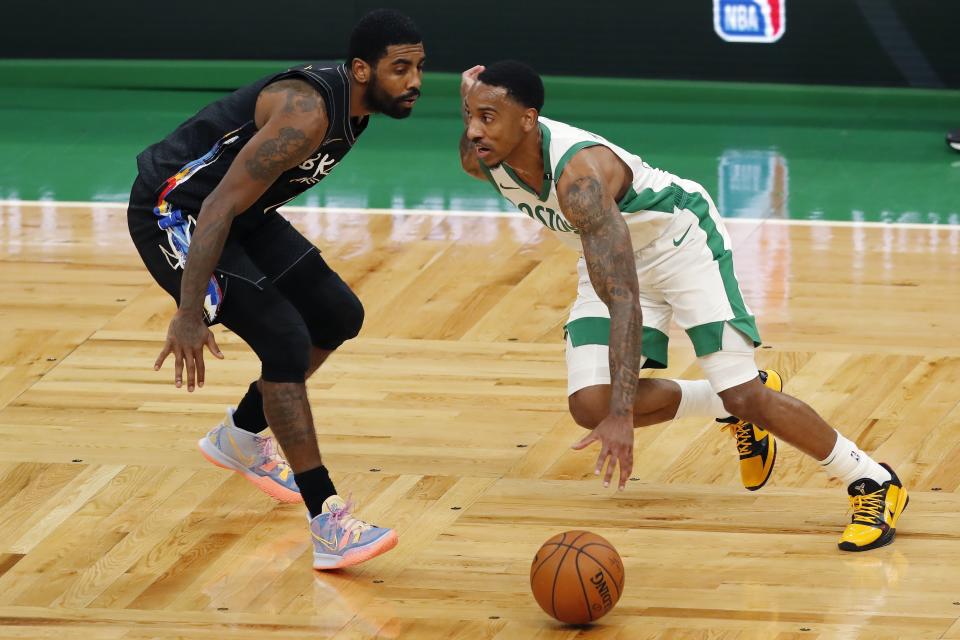 Boston Celtics' Jeff Teague, right, drives past Brooklyn Nets' Kyrie Irving during the first half of an NBA basketball game, Friday, Dec. 25, 2020, in Boston. (AP Photo/Michael Dwyer)