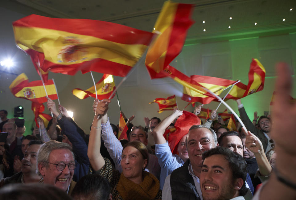 In this Sunday, Dec. 2, 2018 photo, supporters of Spain's far-right Vox party, wave Spanish flags as they celebrate the results during regional elections in Andalusia, in Seville, Spain. The Socialists won just 33 seats in the Andalusia legislature, compared to 47 in 2015. The party could lose control of Spain's most populated region for the first time in 36 years if parties on the right can agree to form a government. The anti-immigrant, extreme right Vox party won 12 seats - its first in any Spanish legislative body. (AP Photo/Gogo Lobato)