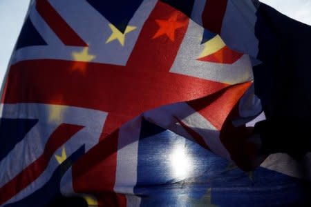 Anti-Brexit demonstrators wave EU and Union flags outside the Houses of Parliament in London, Britain, January 30, 2018. REUTERS/Toby Melville