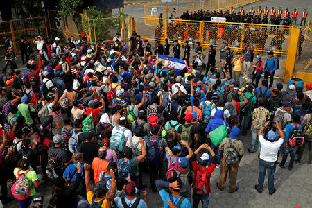 Central Americans, part of a caravan trying to reach the U.S., stand by the border gate in hope to cross into Mexico and carry on their journey, in Tecun Uman, Guatemala, October 28, 2018. REUTERS/Carlos Garcia Rawlins