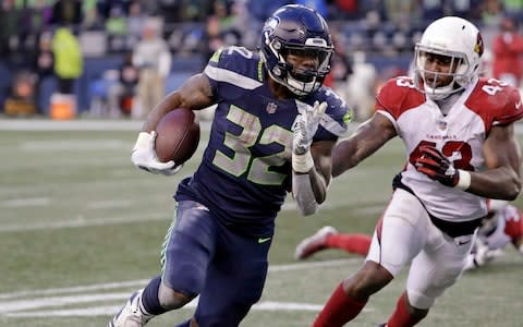 Seattle Seahawks' Chris Carson carries as Arizona Cardinals' Haason Reddick (43) pursues during the second half of an NFL football game - Credit: AP