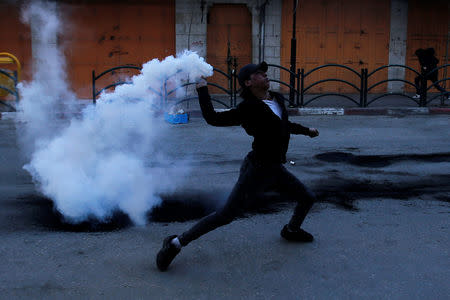 A Palestinian protester returns a tear gas canister fired by Israeli troops during clashes in Hebron, in the occupied West Bank March 29, 2019. REUTERS/Mussa Qawasma
