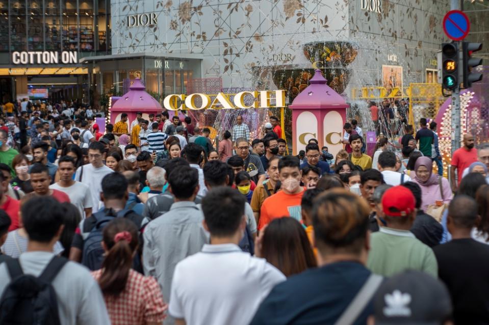 People crossing the street at Pavilion in Kuala Lumpur during a public holiday in conjunction with Hari Raya Aidilfitri, April 23, 2023. — Picture by Shafwan Zaidon