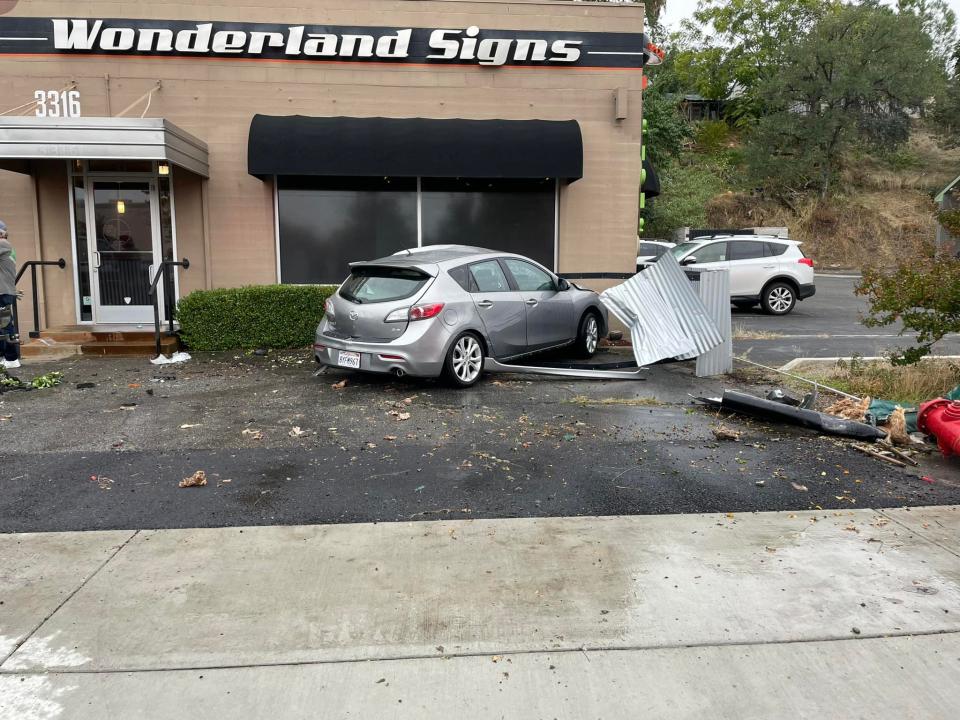 The scene in front of Wonderland Signs in south Redding on Monday, Oct. 9, 2023, after a Mazda 3 left the roadway and careened through the parking lot, hitting a fire hydrant and two unoccupied parked vehicles.