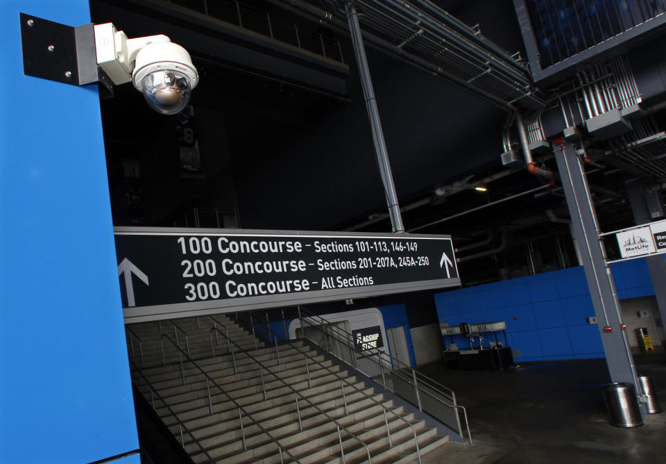 FILE - In this Oct. 15, 2014, file photo, a security camera, upper left, is mounted near a stairway at MetLife Stadium, home of the New York Giants and the New York Jets football teams, in East Rutherford, N.J. Dave Karls has Bucks season tickets and is eager enough for his next visit to Fiserv Forum that having his location trackable in the arena would not interfere with the enjoyment. “I’d much rather have that than not be able to attend the game at all,” Karls said. Such concern depends on an individual's definition of surveillance, a word that carries nefarious connotation in some corners. (AP Photo/Mel Evans, File)