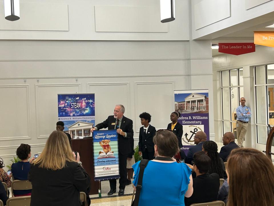 GA State Superintendent Richard Woods shows off literacy banner to Andrea B. Williams Elementary students during a ceremony in Sept. 2023 to commemorate the school's literacy leader award alongside other SCCPSS schools.