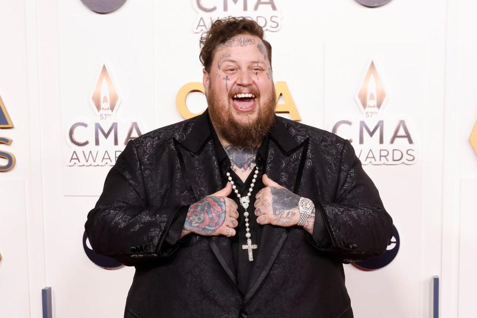 jelly roll smiling for a picture on the cmas red carpet