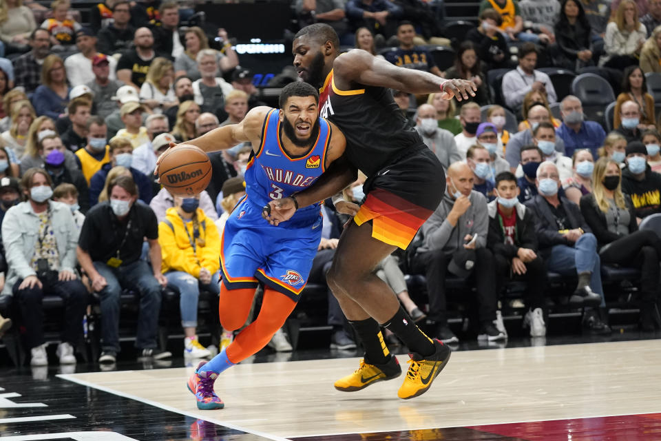 Oklahoma City Thunder forward Kenrich Williams (34) drives as Utah Jazz forward Eric Paschall (0) defends during the first half of an NBA basketball game Wednesday, Oct. 20, 2021, in Salt Lake City. (AP Photo/Rick Bowmer)