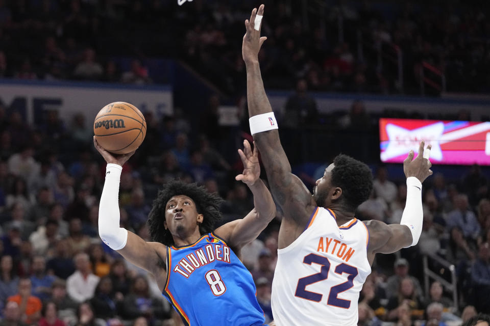 Oklahoma City Thunder forward Jalen Williams (8) shoots in front of Phoenix Suns center Deandre Ayton (22) in the first half of an NBA basketball game Sunday, April 2, 2023, in Oklahoma City. (AP Photo/Sue Ogrocki)