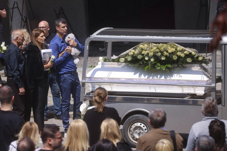 Parents of Ema Kobiljski, 13, mourn during the funeral procession at the central cemetery in Belgrade, Serbia, Saturday, May 6, 2023. Her schoolmate, a 13-year-old boy, on Wednesday, used his father's guns to kill eight fellow students and a guard. (AP Photo/Armin Durgut)