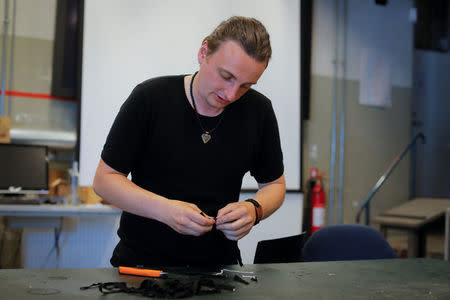 Mathias Vidas Olsen, 29, a viking-age replica jewellery maker under the label Ravnsgard Smykker, demonstrates the preparation of bracelets he designed with a phrase that translates to "I will go with the burqa, will you?" in Copenhagen, Denmark., July 25, 2018. Olsen created the bracelets to raise money for the group Kvinder I Dialog (Women In Dialogue). REUTERS/Andrew Kelly