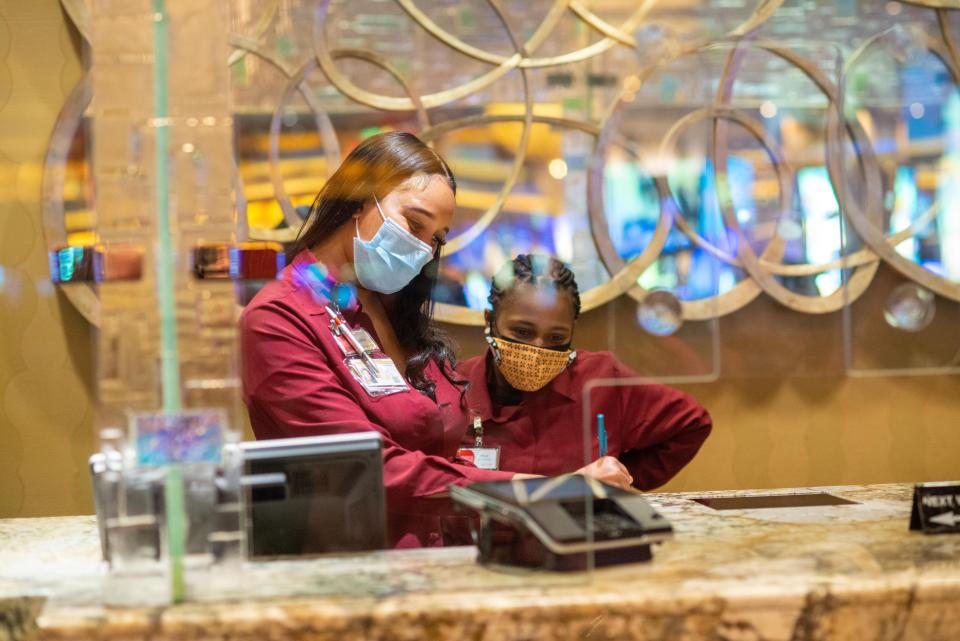 Cashier Lyvia Harris, left, trains new employee Mia Hunt during their shift in the cage at Parx Casino in Bensalem on Thursday, Jan. 20, 2022.