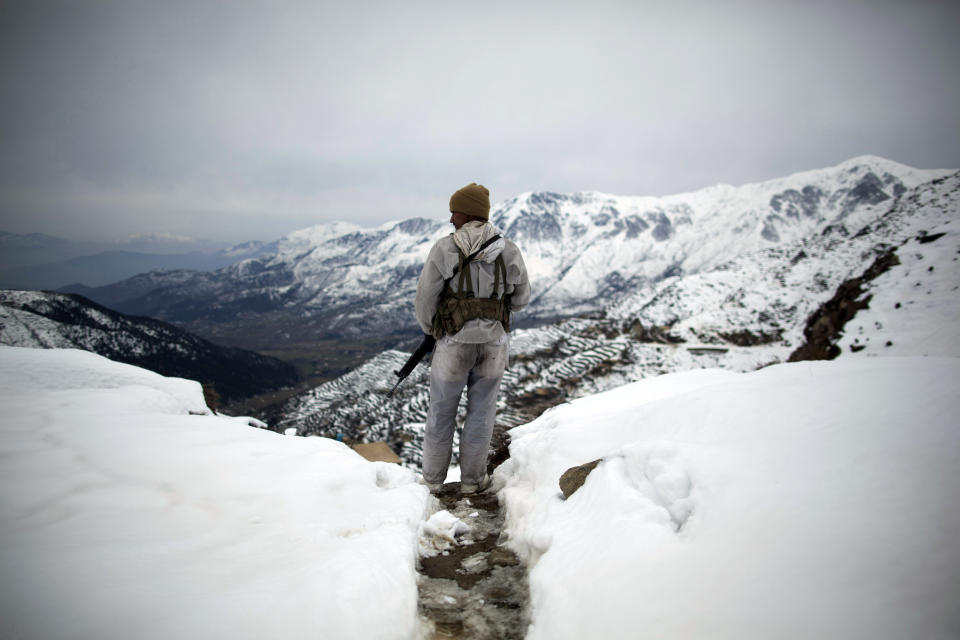 FILE - In this Friday, Feb. 17, 2012 file photo made by Associated Press photographer Anja Niedringhaus, a Pakistani Army soldier with the 20th Lancers Armored Regiment stands atop the 8000-foot mountain during a patrol near his outpost, Kalpani Base, in Pakistan's Dir province on the Pakistan-Afghan border. Niedringhaus, 48, an internationally acclaimed German photographer, was killed and an AP reporter was wounded on Friday, April 4, 2014 when an Afghan policeman opened fire while they were sitting in their car in eastern Afghanistan. (AP Photo/Anja Niedringhaus, File)