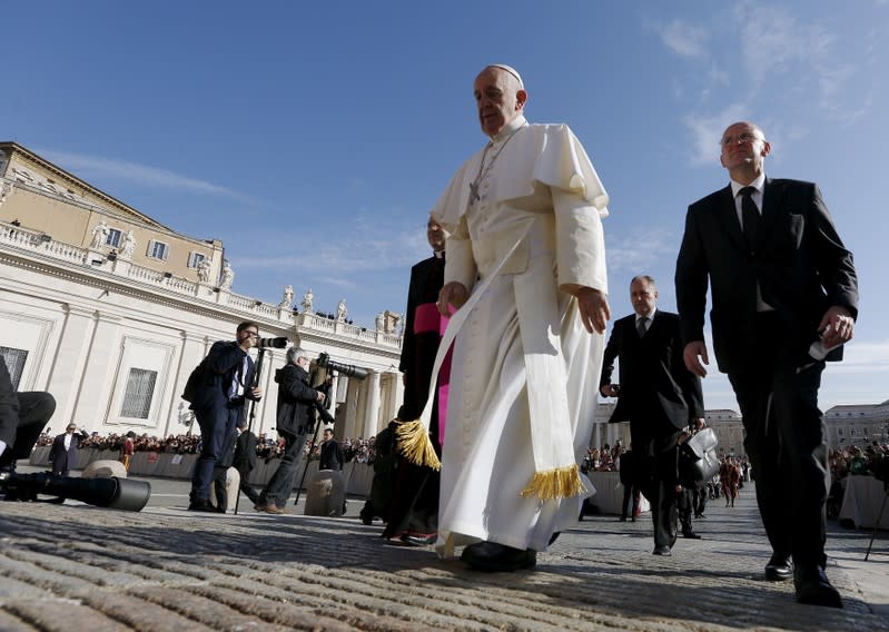 FILE PHOTO: Pope Francis arrives flanked by Chief of Vatican City security Giani to lead the weekly audience in Saint Peter's Square at the Vatican