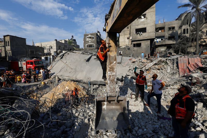 Emergency personnel work at the site of Israeli strikes on houses, in Khan Younis