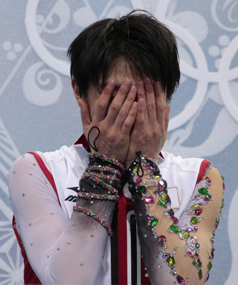 Yuzuru Hanyu of Japan reacts as he sits in the results area after the men's free skate figure skating final at the Iceberg Skating Palace at the 2014 Winter Olympics, Friday, Feb. 14, 2014, in Sochi, Russia. (AP Photo/Ivan Sekretarev)