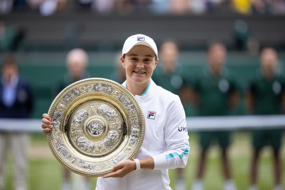 Ash Barty (pictured) smiles and poses with the Wimbledon trophy.