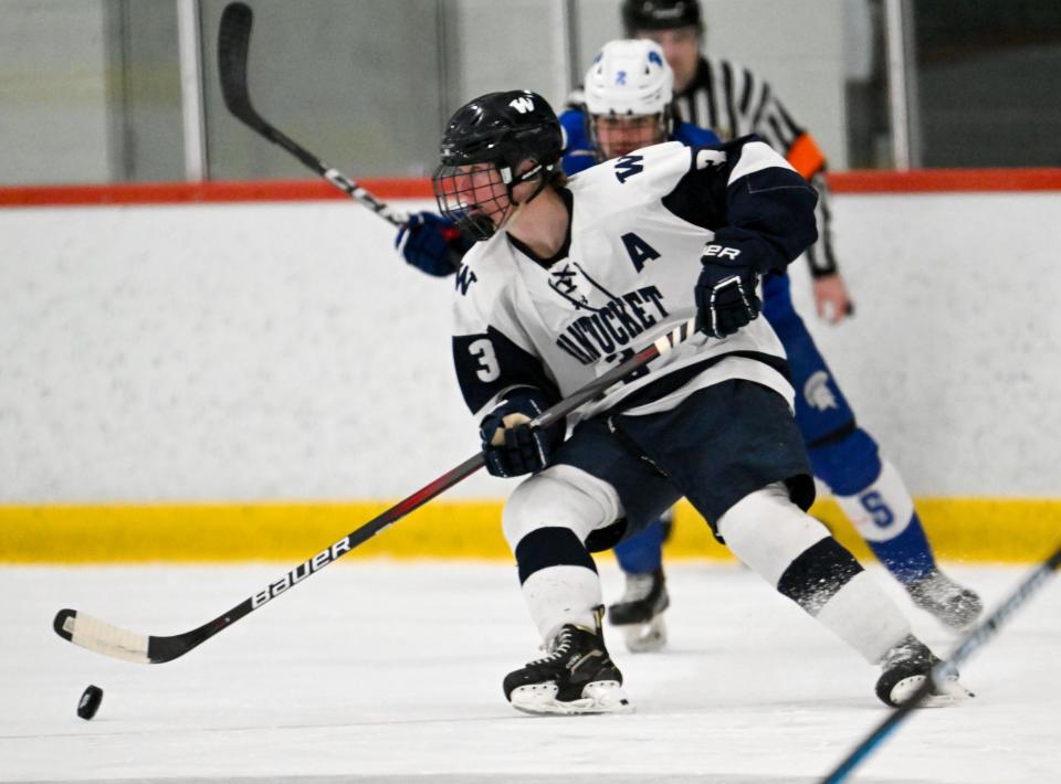 Michael Culkins of Nantucket pushes the puck ahead of Joe Aronis of Stoneham. Nantucket's title dream came to an end when Stoneham defeated the Whalers 4-1 in Elite Eight competition.