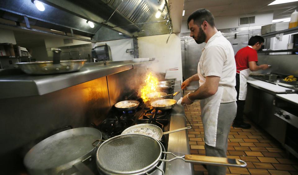 Pasta Al Forno Italian restaurant co-owner and chef Aron Dreshaj cooks meals for customers in the restaurant's kitchen on Friday, May 19, 2023, i13th Street, n Ames, Iowa.