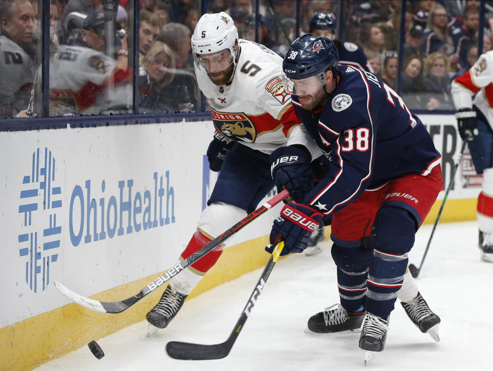 Florida Panthers' Aaron Ekblad, left, and Columbus Blue Jackets' Boone Jenner compete for the puck during the second period of an NHL hockey game Tuesday, Dec. 31, 2019, in Columbus, Ohio. (AP Photo/Jay LaPrete)