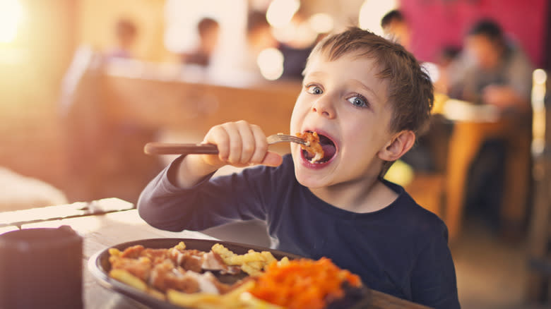 Young kid eating in restaurant