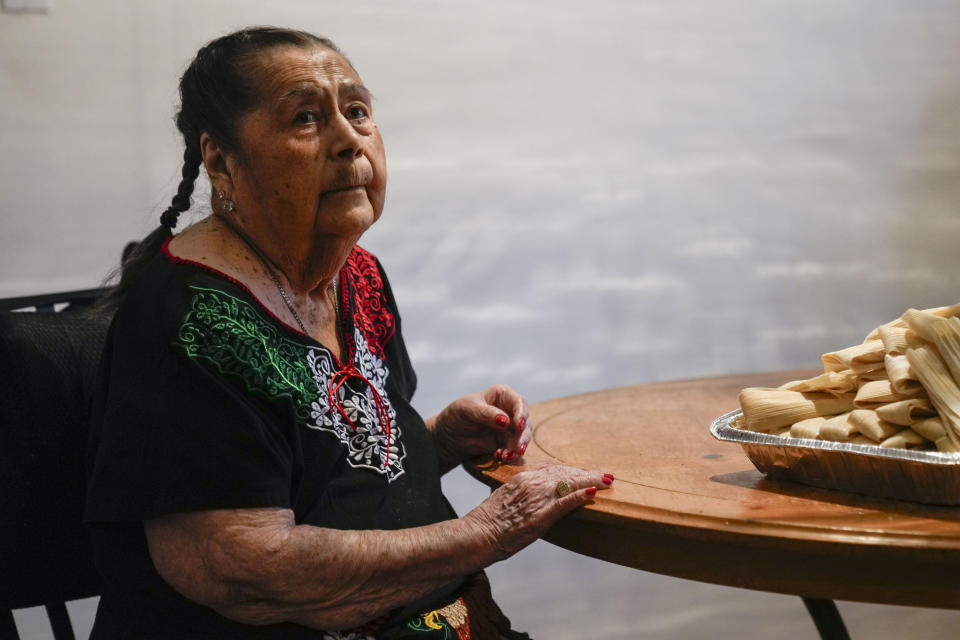 Aurora Sandoval waits for the next step in tamale-making with her family members at the family home Tuesday, Dec. 26, 2023, in Chicago. When she was 1, Noelia Sanchez and her mother Aurora, who had no work documents, were rounded up with dozens of other immigrants in a Texas town near the border. The U.S.-born child and her mother were forced to go to Mexico along with hundreds of thousands of other people. (AP Photo/Erin Hooley)