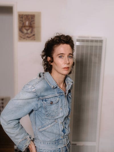 A woman posing in a denim jacket.