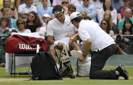 Britain Tennis - Wimbledon - All England Lawn Tennis & Croquet Club, Wimbledon, England - 8/7/16 Switzerland's Roger Federer receives medical attention after falling in his match against Canada's Milos Raonic REUTERS/Tony O'Brien