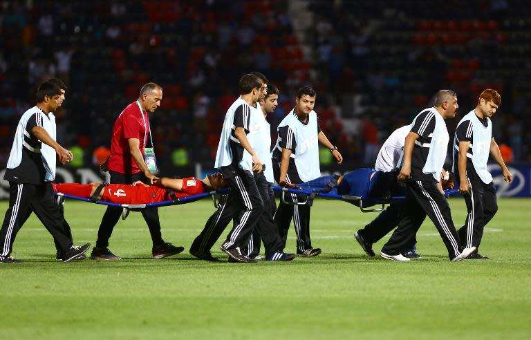 Thibaut Vion of France (R) and Hakan Cinemre of Turkey are taken off the pitch after sustaining injuries during their match at the FIFA Under 20 World Cup at the Kamil Ocak stadium in Gaziantep, on July 2, 2013