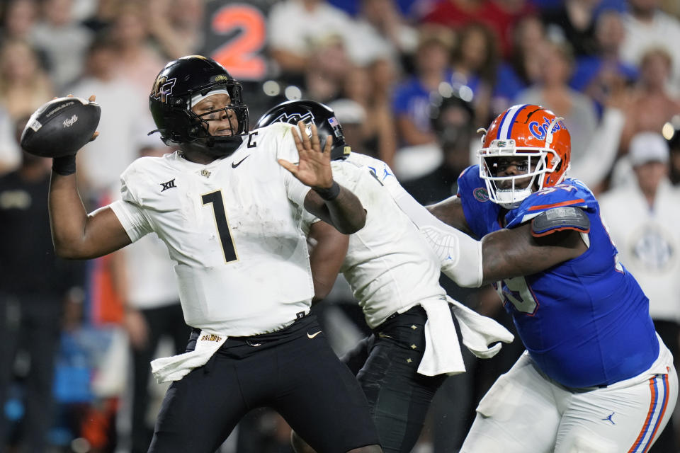 Central Florida quarterback KJ Jefferson (1) throws a pass as Florida defensive lineman Cam Jackson rushes during the first half of an NCAA college football game, Saturday, Oct. 5, 2024, in Gainesville, Fla. (AP Photo/John Raoux)